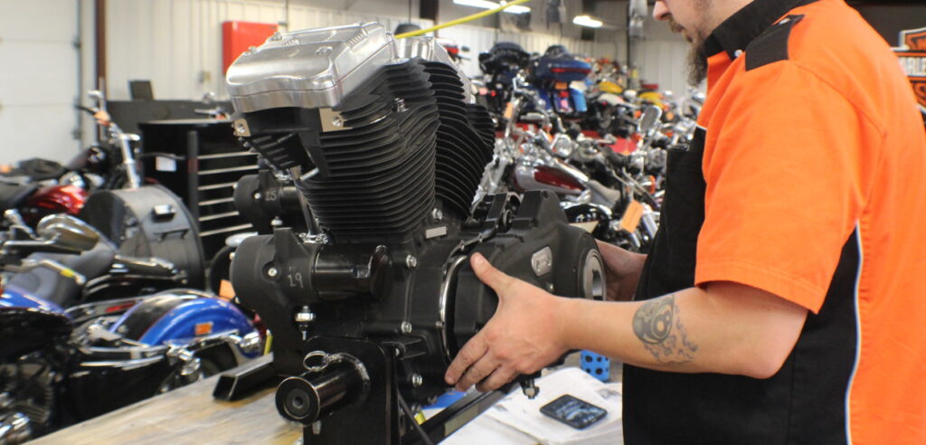 A Harley-Davidson student works on a motor