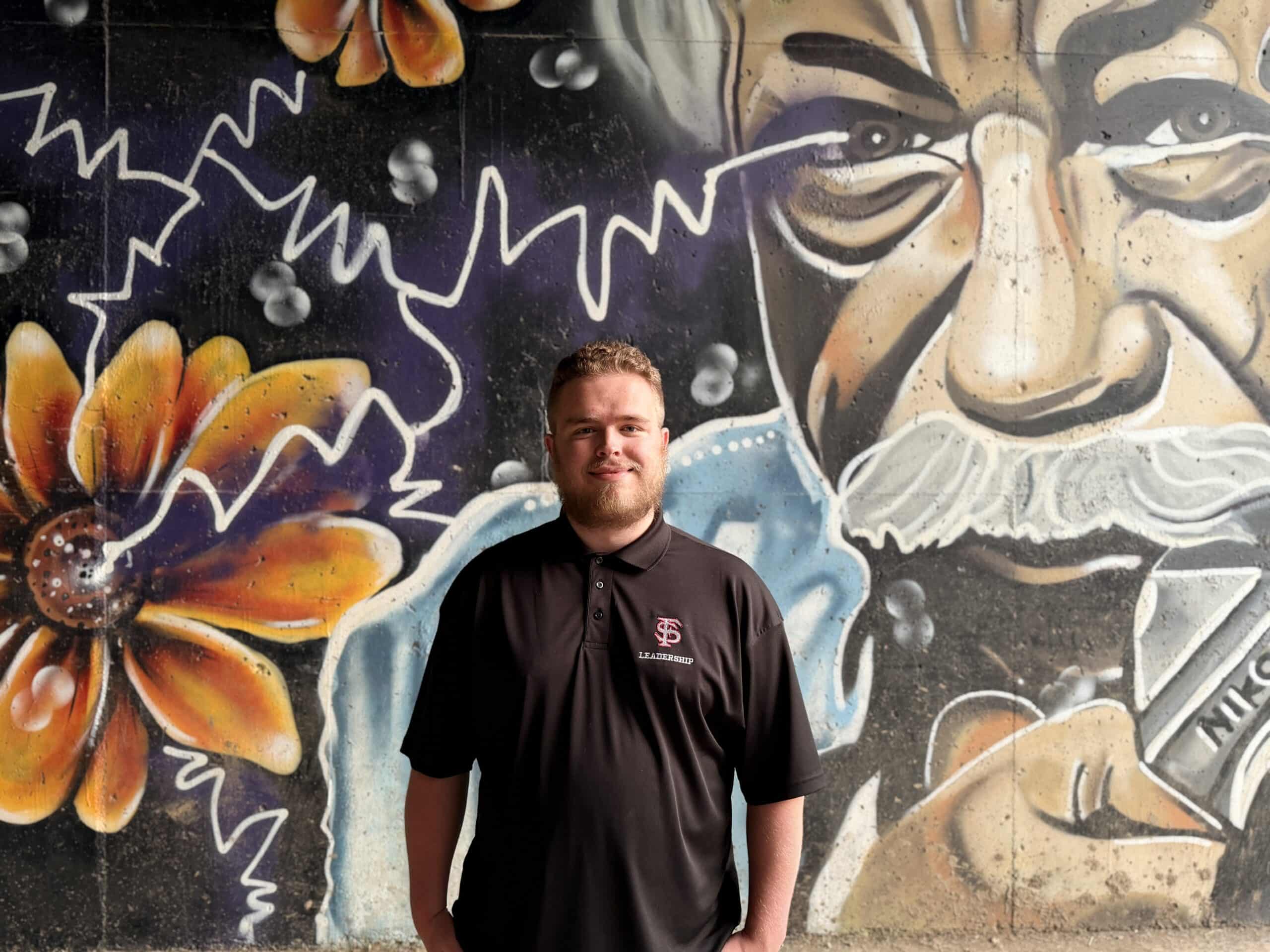 Zach Grant photo in front of a Gordon Parks mural